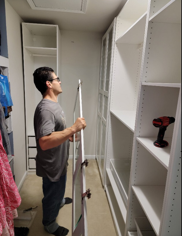 Owner Ralph Gomez installing custom cabinetry inside a walk-in closet.